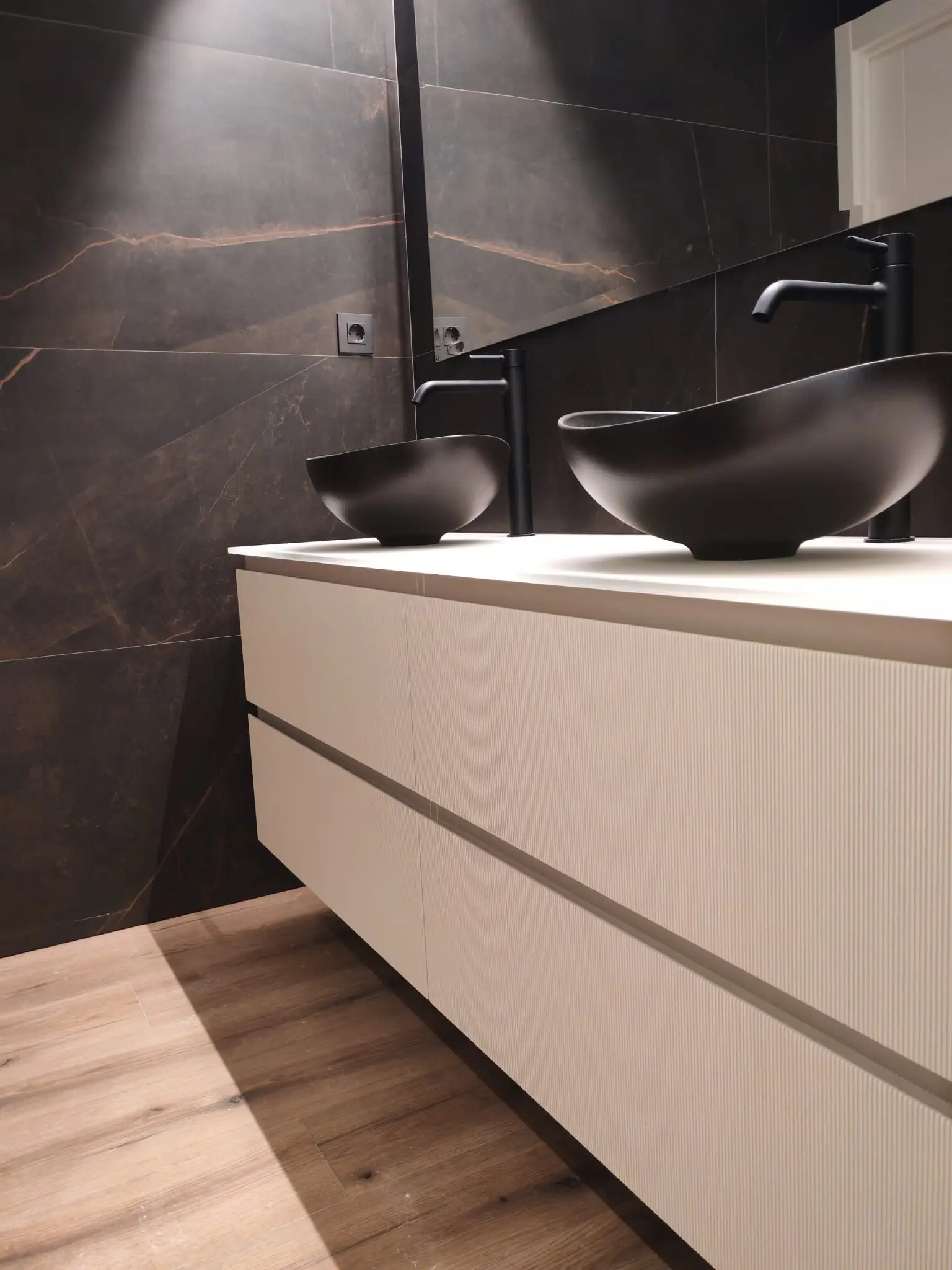 Reforma de baño con lavabos sobre encimera negros y mueble suspendido blanco en Barakaldo