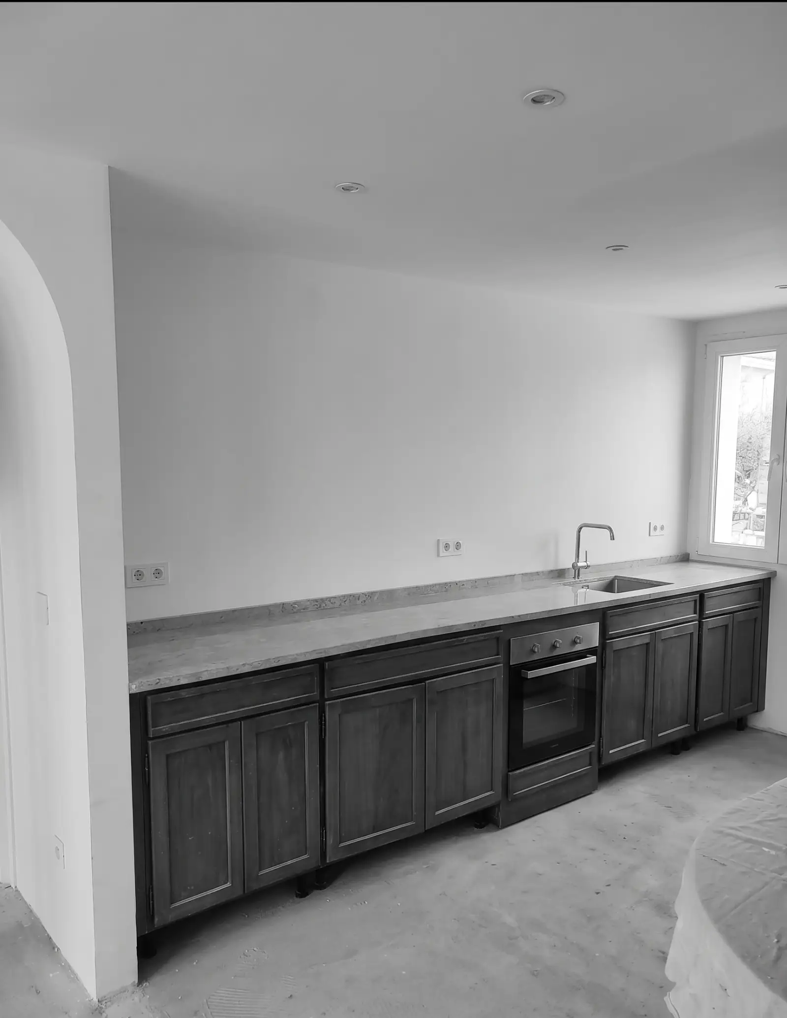 Reforma de cocina con muebles de madera oscura y encimera de piedra gris en Barakaldo